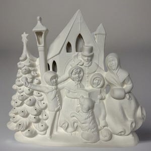 May include: White ceramic Christmas scene with a church, a Christmas tree, a street lamp, and a family singing carols. The family includes a man, a woman, and two children. A dog is standing next to the family. The scene is ready to be painted.