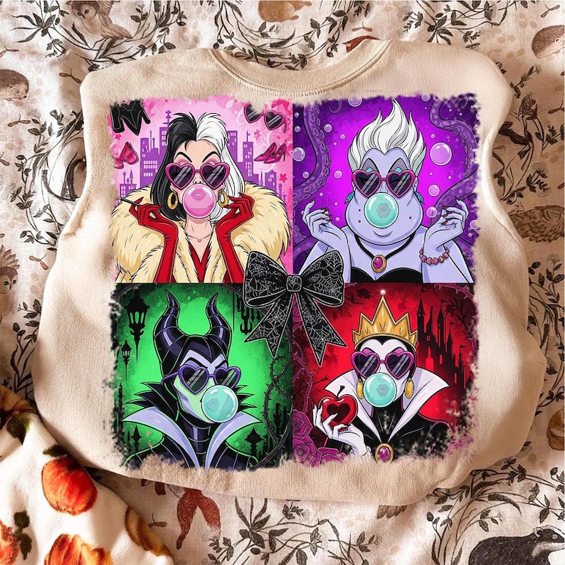 May include: Beige sweatshirt featuring a colorful graphic of four cartoon villains blowing bubble gum bubbles. Each villain is in a square, with a black bow in the center. The villains are Cruella, Ursula, Maleficent, and the Evil Queen.
