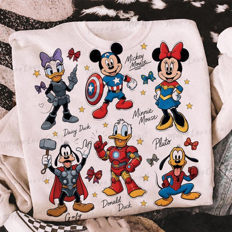May include: White sweatshirt featuring cartoon characters Mickey Mouse, Minnie Mouse, Donald Duck, Daisy Duck, Goofy, and Pluto dressed as superheroes. The design includes stars and bows, with character names below each figure.