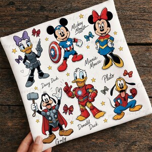 May include: White fabric featuring cartoon characters Mickey Mouse, Minnie Mouse, Donald Duck, Daisy Duck, Goofy, and Pluto in superhero costumes. The design includes stars and bows, with character names below.