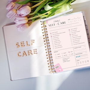 May include: A pink and white self-care checklist planner with a gold spiral binding. The checklist includes items like "Take a long bath", "Go for a walk", "Meditate", and "Read a new book".