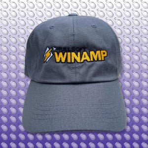 May include: A gray baseball cap with a yellow and black embroidered logo that says "Winamp by Nullsoft".