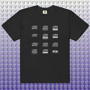 Może przedstawiać: Czarny t-shirt z wieloma białymi logotypami "disc" i tekstem takim jak "Digital Audio", "Graphics" i "Photo". Mała metka jest widoczna w pobliżu kołnierza koszulki.