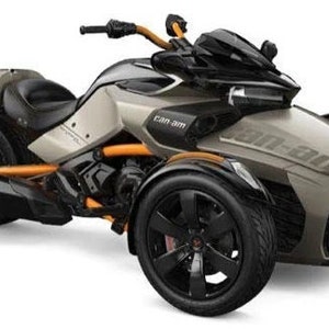 Puede incluir: Una motocicleta Can-Am Spyder gris y negra con detalles en naranja. La motocicleta tiene tres ruedas y un asiento de cuero negro.