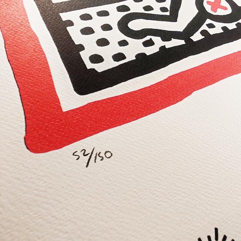 May include: A black and white print with a red border. The print features a black and white design with a red cross. The print is numbered 52/150.