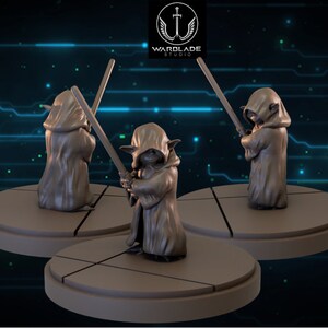 Peut inclure: Trois figurines miniatures d'un personnage fictif de la franchise Star Wars. Chaque figurine porte une robe brune et tient un sabre laser. Les figurines sont posées sur des socles circulaires.