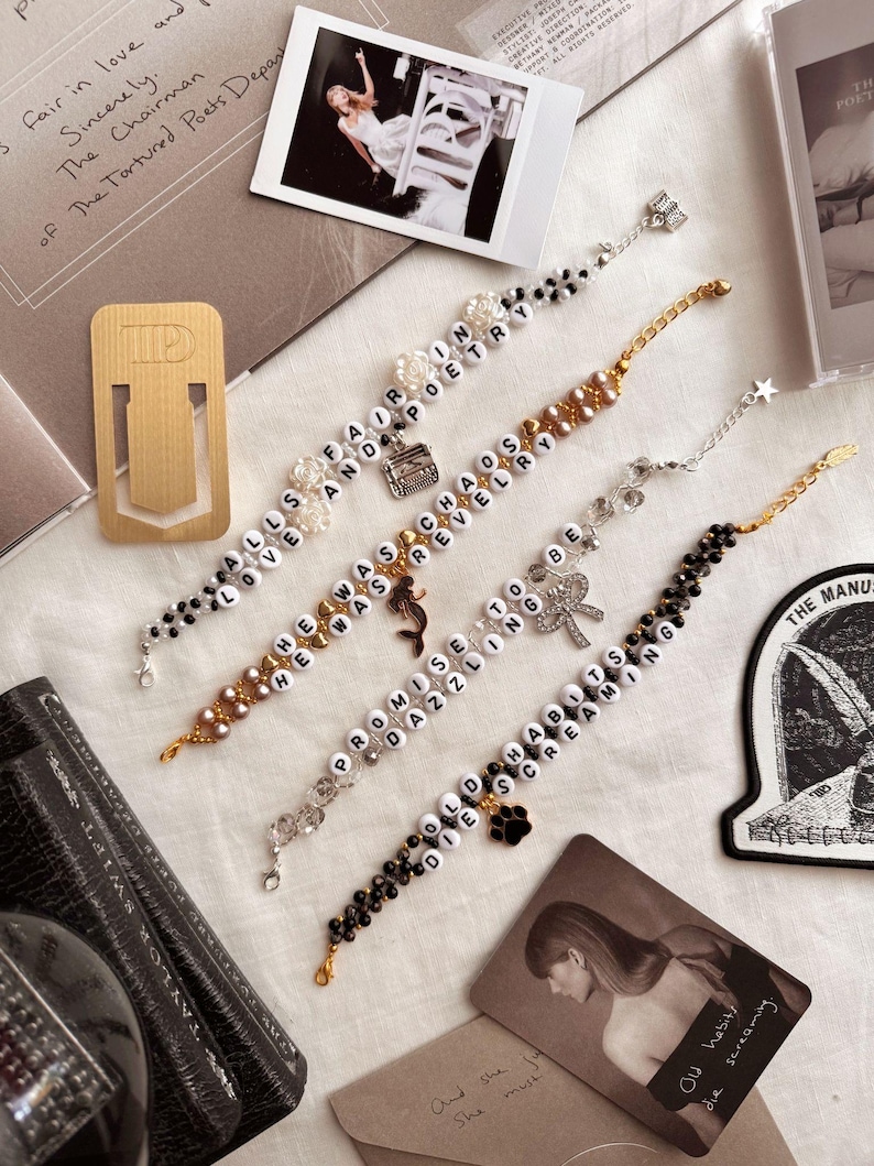 May include: Four beaded bracelets with charms. The bracelets feature white letter beads spelling out phrases: "Alls Love Far On And Poetry", "He Was Cha Os Revelry", "Promise To Be Dazzling", and "Old Habits Die Screaming".