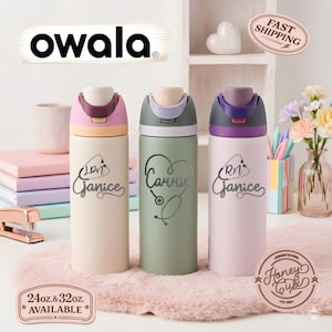 May include: Three personalized Owala water bottles in pastel colors: pink, green, and lavender. Each bottle has a different name and medical symbol design. The bottles are available in 24oz and 32oz sizes. The Owala logo is at the top.