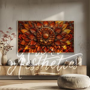 May include: A framed wall art print featuring a large, intricate wooden carving of a flower with a circular center. The carving is painted in shades of orange, red, and yellow.