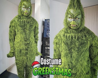 May include: A green costume with a character mask. The mask has a detailed face with yellow eyes and a grumpy expression. The costume is labelled "Costume GREENSTMAS". The text "Foam belly not included" is also visible.