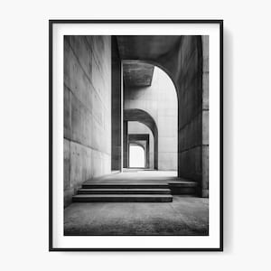 May include: Monochrome photograph of an architectural space with a sequence of archways leading towards a distant light. The image showcases concrete walls, steps, and a framed presentation.