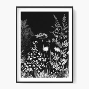 May include: Monochrome botanical print depicting detailed illustrations of wildflowers and foliage. The artwork is framed in a black border, creating a striking contrast. The print showcases a range of textures and shapes, ideal for adding a touch of nature to any space.
