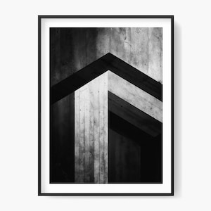 Könnte beinhalten: Schwarz-Weiß-Druck mit Rahmen, der ein abstraktes architektonisches Design zeigt. Das Bild zeigt das Spiel von Licht und Schatten auf Betonstrukturen und erzeugt eine geometrische Komposition. Das Kunstwerk ist ein modernes, minimalistisches Stück.