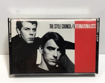 May include: A black and white cassette tape with a red and white label. The label reads "THE STYLE COUNCIL/INTERNATIONALISTS".