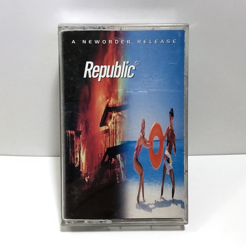 K&ouml;nnte beinhalten: Eine Kassette mit dem Vermerk "New Order Release" mit einem roten, orangen und gelben Feuerbild auf der linken Seite und einem blauen Himmel- und Meeresbild auf der rechten Seite. Die Kassette tr&auml;gt den Text "Republic" in wei&szlig;en Buchstaben auf schwarzem Hintergrund.