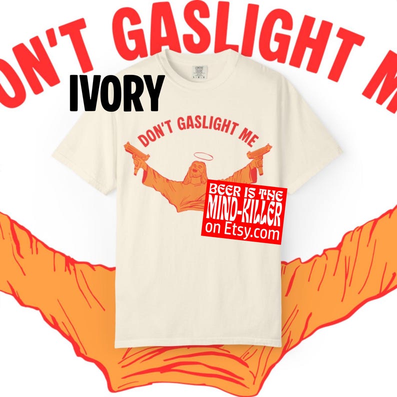May include: Ivory-colored t-shirt with the text "DON'T GASLIGHT ME" in red. The shirt features an orange graphic of a figure holding guns, with a halo. A red square reads "BEER IS THE MIND-KILLER on Etsy.com".