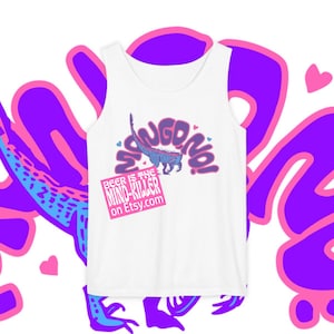 Peut inclure: Débardeur blanc avec un motif graphique représentant un dinosaure bleu et violet et les mots "SANGDINO!" en violet. Un rectangle rose indique "BEER IS THE MIND-KILLER on Etsy.com". Le motif est entouré de formes violettes et roses.