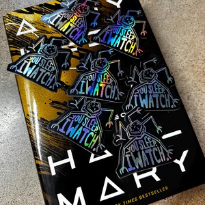 May include: A set of six iridescent holographic stickers featuring a cartoon figure with the text "You Sleep, I Watch."