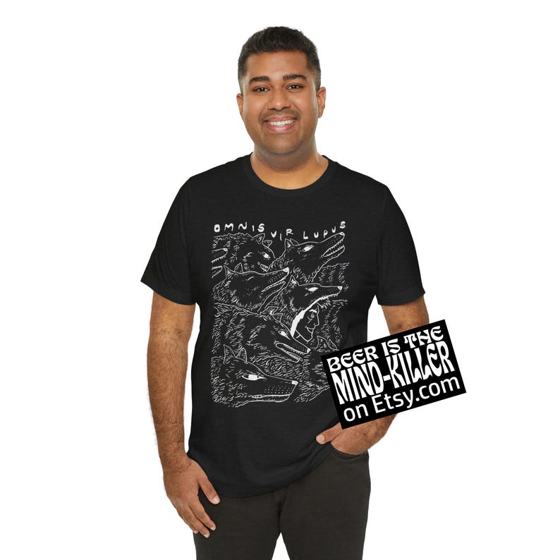 May include: Black t-shirt featuring a white illustration of wolves and the text "OMNIS VIR LUPUS". The shirt also has a small sign that says "BEER IS THE MIND-KILLER on Etsy.com".