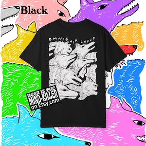 K&ouml;nnte beinhalten: Schwarzes T-Shirt mit einem Wolf-Motiv und dem Text "OMNIS VIR LUPUS". Das Shirt ist von bunten Wolfsillustrationen umgeben. Der Text "BEER IS THE MIND-KILLER on Etsy.com" ist ebenfalls sichtbar.