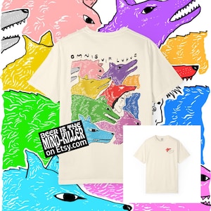 May include: Cream-colored t-shirt featuring a colorful wolf pack design with the text "OMNIS VIR LUPUS." The shirt also has a small wolf graphic on the front. The image includes the text "BEER IS THE MIND-KILLER on Etsy.com."