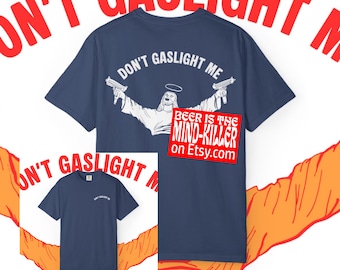 Può includere: T-shirt blu navy con la scritta "DON'T GASLIGHT ME" e una grafica di una figura che tiene due pistole. La frase "BEER IS THE MIND-KILLER" è su un rettangolo rosso con un indirizzo web.