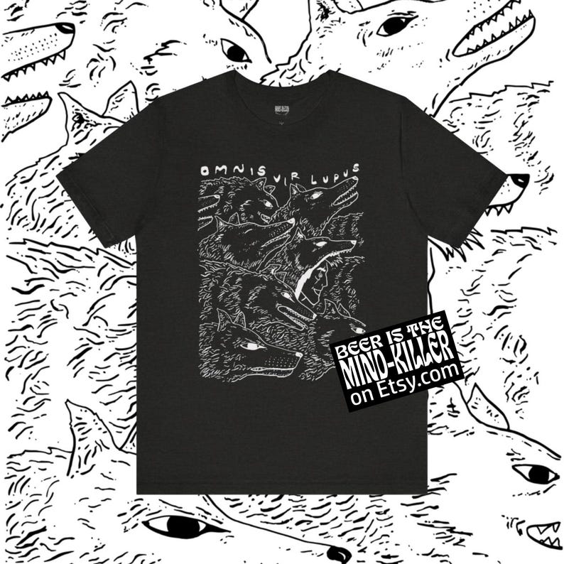 May include: Black t-shirt featuring a detailed white illustration of several wolf heads with the text "OMNIS VIR LUPUS". The shirt also has a small rectangular graphic that says "BEER IS THE MIND-KILLER on Etsy.com".