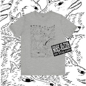 May include: A heather gray t-shirt featuring a black and white illustration of wolves with the text "OMNIS VIR LUPUS". The shirt also has a sticker that says "BEER IS THE MIND-KILLER on Etsy.com".