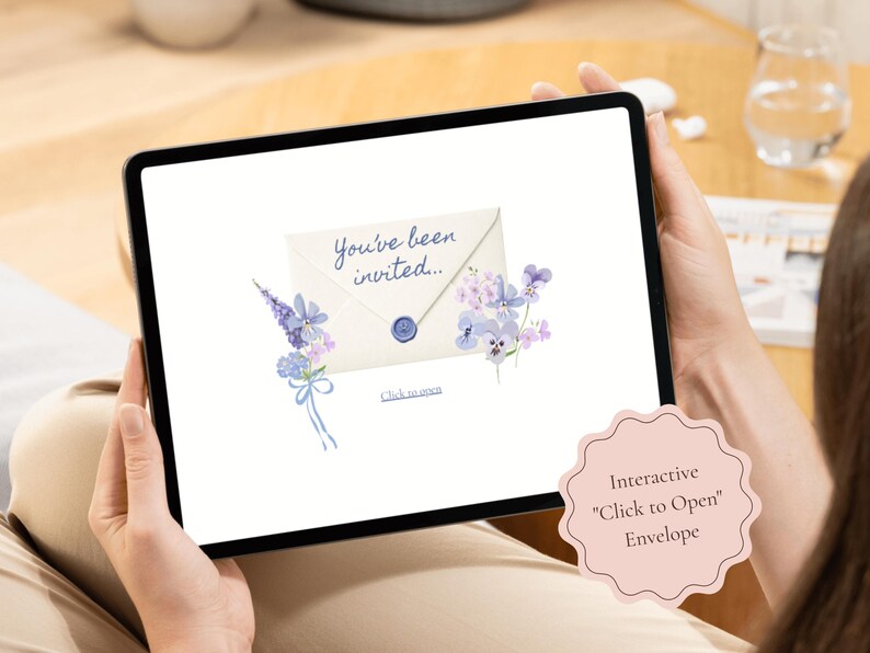 Tablet displaying the animated click-to-open envelope for the Baby in Bloom blue baby shower website invitation, decorated with soft watercolor wildflowers and delicate botanical details.