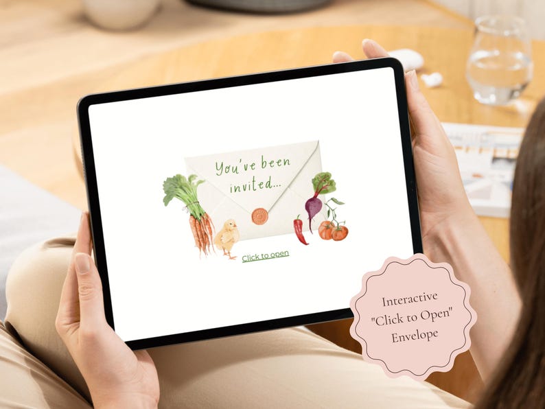 A tablet showing the interactive baby shower invitation cover with a click-to-open envelope decorated with carrots, tomatoes, and a chick for a Locally Grown baby shower theme.