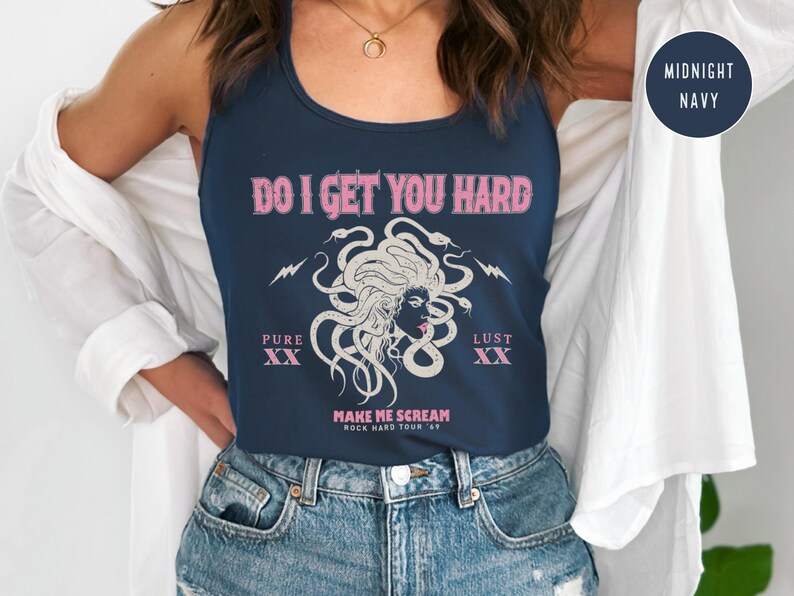 May include: A navy blue vest top with the pink text "DO I GET YOU HARD". The design includes a Medusa illustration with snakes and lightning bolts. The text "PURE XX" and "LUST XX" are also present.