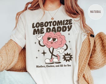 May include: White t-shirt with a cartoon brain wearing sneakers and the text "Lobotomoize Me Daddy" and "Mindless, Clueless, and All for You".