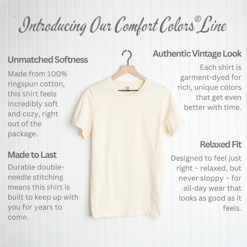 May include: A cream-colored t-shirt hangs on a wooden hanger against a white background. The shirt is part of the Comfort Colors line, made from ringspun cotton. Text on the left describes the shirt's softness and durability. Text on the right highlights its vintage look and relaxed fit.
