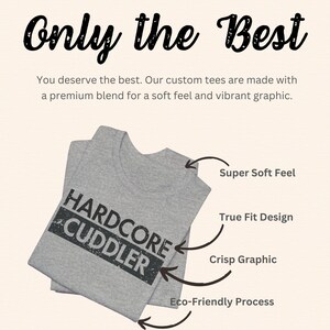 Puede incluir: Una camiseta gris con el texto "HARDCORE CUDDLER" impreso en ella. La camiseta est&aacute; doblada y tiene flechas que apuntan a las caracter&iacute;sticas de la camiseta, incluyendo "Super Soft Feel", "True Fit Design", "Crisp Graphic" y "Eco-Friendly Process".