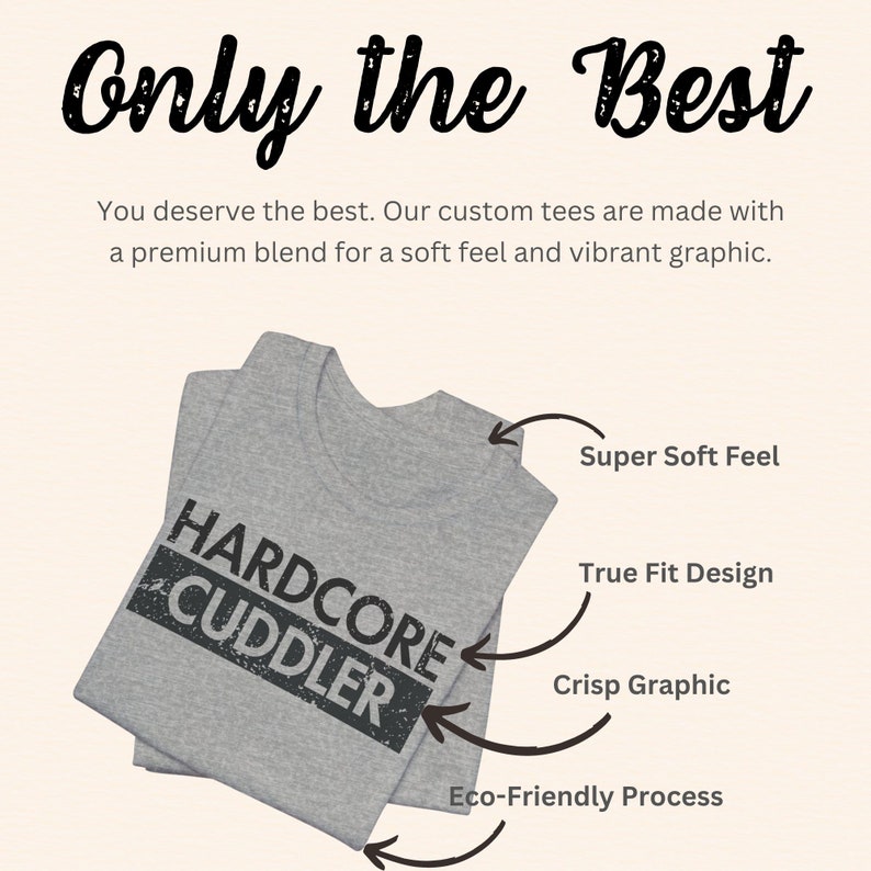 Puede incluir: Una camiseta gris con el texto "HARDCORE CUDDLER" impreso en ella. La camiseta est&aacute; doblada y tiene flechas que apuntan a las caracter&iacute;sticas de la camiseta, incluyendo "Super Soft Feel", "True Fit Design", "Crisp Graphic" y "Eco-Friendly Process".