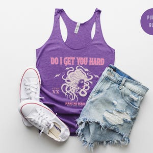 May include: A purple vest top with the text "DO I GET YOU HARD" and a Medusa graphic, alongside distressed denim shorts and white trainers. A purple circle with "PURPLE RUSH" is in the top right corner.