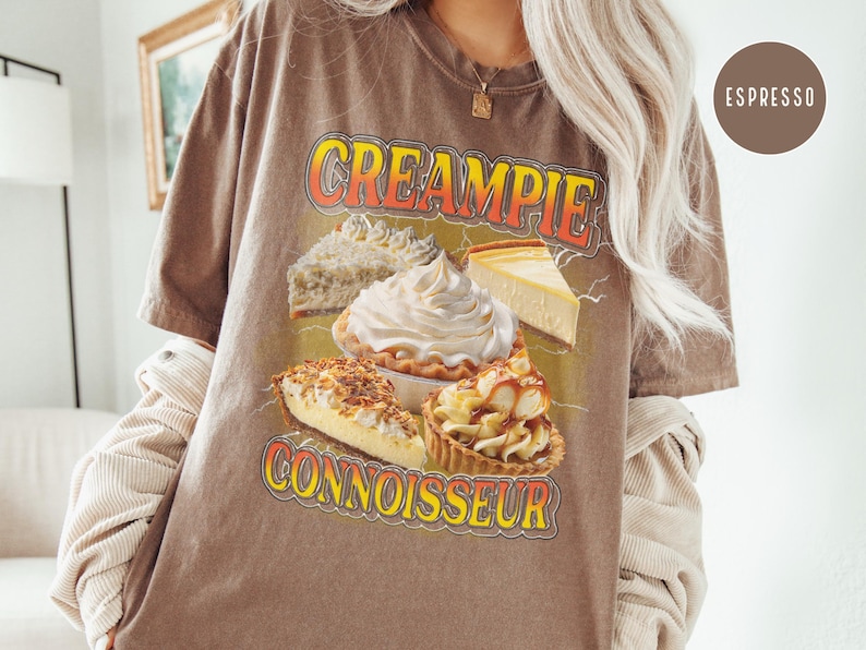 May include: Brown t-shirt with a graphic of various pies and the text "CREAMPIE CONNOISSEUR".