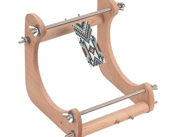 May include: A light-coloured wooden bead loom featuring two curved side supports, two horizontal metal rods with threaded ends, and silver wing nuts. A partially completed beaded strip with a geometric pattern in teal, white, and brown is attached.
