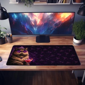 May include: A rectangular desk mat featuring a dark purple background with a repeating pattern of small tiaras and martini glasses. On the left side, a fluffy brown cat wears a tiara and purple sunglasses while holding a red martini glass.