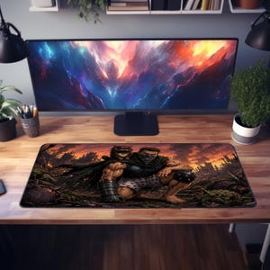 May include: A rectangular mousepad with a detailed illustration of two muscular figures in a dark, fantasy setting. The artwork includes a black cape, armour, and a fiery sunset backdrop. The mousepad is on a wooden desk.