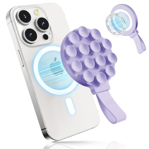 May include: A white smartphone with a triple-lens camera is shown with a light purple phone grip attached. The grip has a circular design with suction cups and a handle. A second grip is shown in the background.