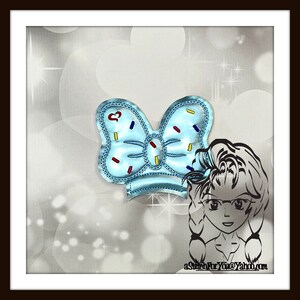 May include: A light blue bow with colorful sprinkles, a heart, and a white outline. The bow is on a white background with a cartoon girl wearing glasses and a braid.