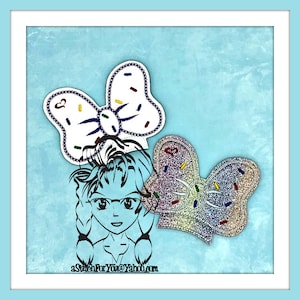 May include: A digital illustration of a girl with a blue bow in her hair. The bow is decorated with white and colorful sprinkles. The girl is wearing a blue shirt and has a blue background. The text "aStitchForYou@Yahoo.com" is at the bottom of the image.