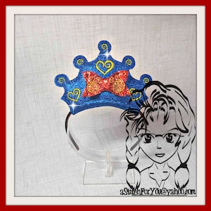 May include: Blue glitter crown headband with a red bow and yellow hearts. The crown is on a white stand with a black silhouette of a person wearing glasses.