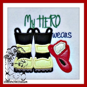 May include: Embroidered design featuring a pair of black and yellow firefighter boots, a red fire helmet, and the text "My Hero wears".