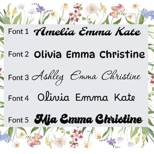 May include: A white rectangular graphic with five font samples, each displaying a name combination: Amelia Emma Kate, Olivia Emma Christine, Ashley Emma Christine, Olivia Emma Kate, and Mia Emma Christine. The graphic is surrounded by a floral border.