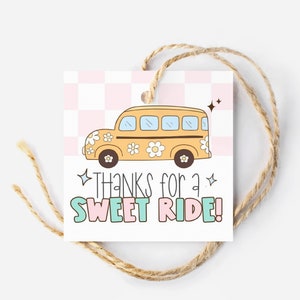 May include: A yellow school bus with flowers on the side and the text "THANKS for a SWEET RIDE!" on a pink and white chequered background.