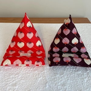 May include: Two triangular fabric tablet stands. One is red with white and pink strawberries, the other is dark purple with pink and white strawberries. Both have a label that reads "COOPER'S CORNER".