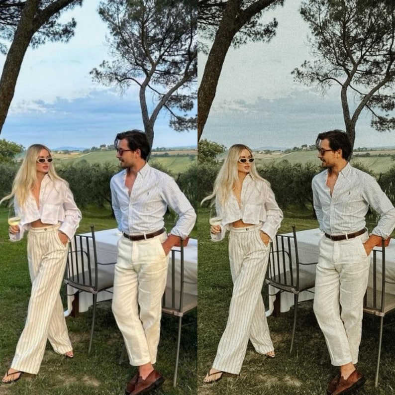 May include: A couple wearing white shirts and striped pants stand in a garden setting. The man is wearing a brown belt and the woman is wearing sunglasses. They are both holding glasses of wine.