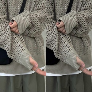 May include: A light brown, open knit sweater with a loose fit and long sleeves. The sweater has a textured, open weave pattern.